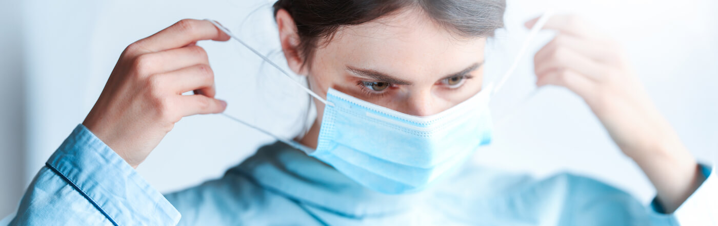 Female doctor holding medical protective mask