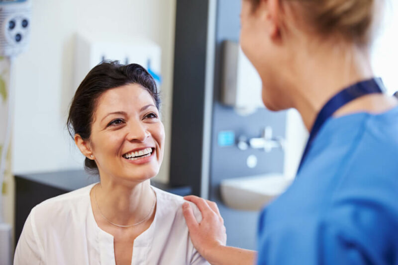 Doctor touching the arm of a smiling patient